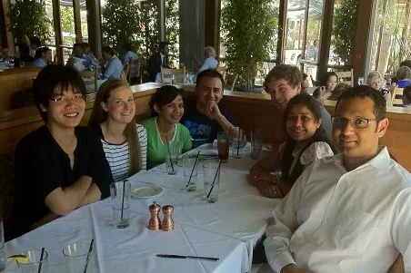 Lab members sit at an outdoor table celebrating the lab's one-year anniversary.